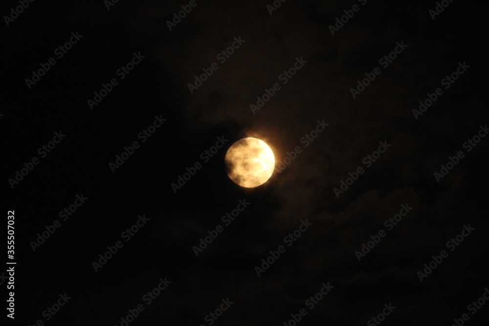 view of the moon on a dark cloudy sky during night