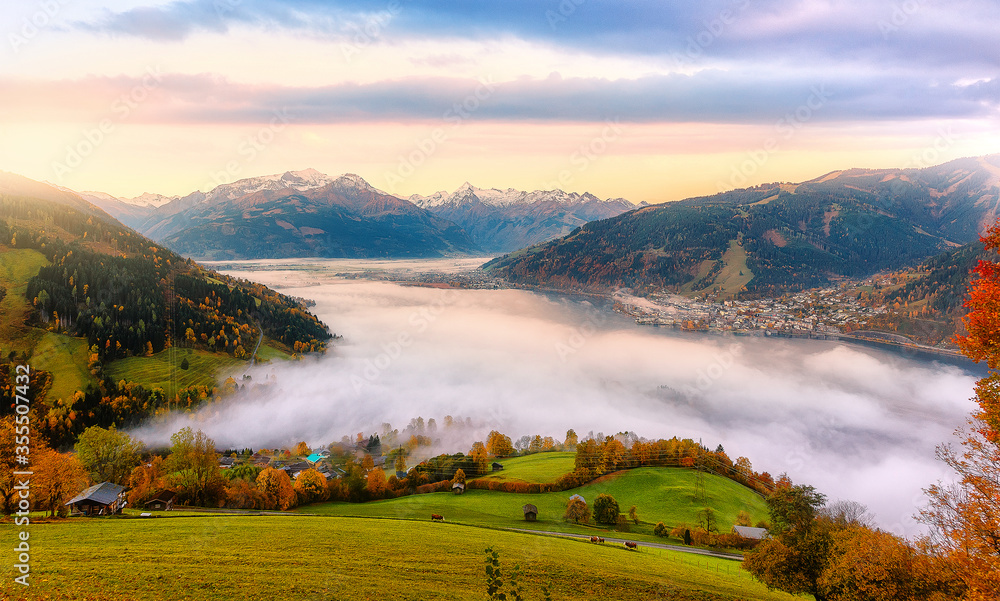 Incredible Nature Landscape. foggy morning during sunrise at Alpine lake in autumn. Colorful Sky over the Zeller Lake in Zell am See, Salzburger Land, Austria. Creative image. Natural Background
