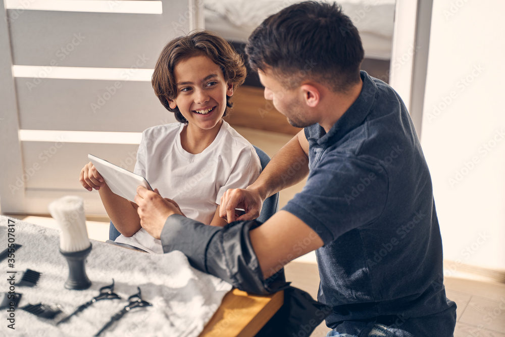 Fototapeta premium Happy little child listening his young father