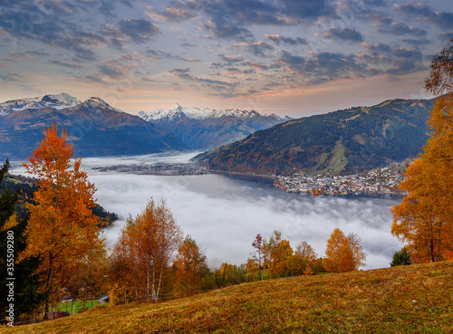 Incredible Nature Landscape. Foggy morning during sunrise at Alpine lake in autumn. Colorful Sky over the Zeller Lake in Zell am See, Salzburger Land, Austria. Creative image. Natural Background