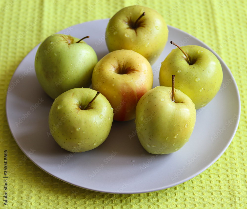 juicy ripe apples on a white plate close up juicy ripe apples on a white plate close up