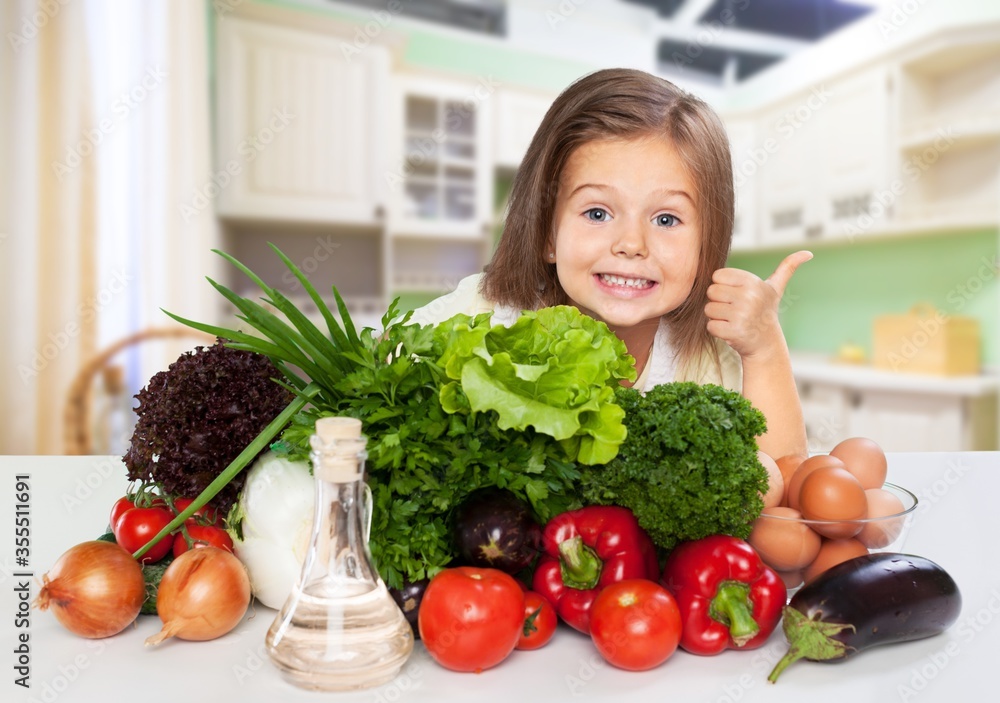 Little happy girl with raw vegetables