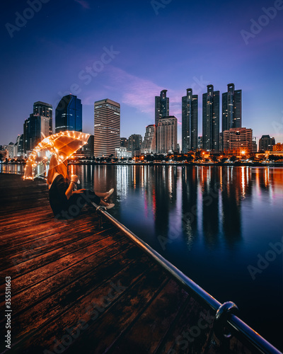 Suan Benja Kitti in Bangkok on Morning time with woman holding light umbrella 