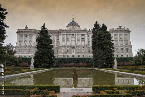 View of the Royal Palace with the pond from the Sabatini Gardens at sunset in Madrid. Spain