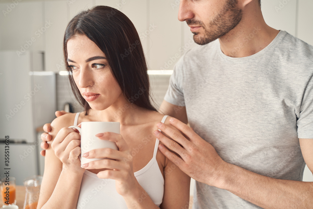 Upset young female feeling support and attention of her husband Upset young female feeling support and attention of her husband