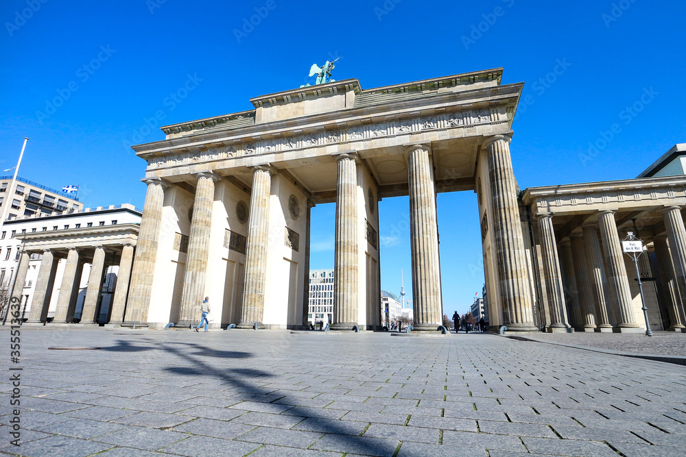 Brandenburg Gate in Berlin, usually a major landmark and tourist hotspot, is mostly deserted during Coronavirus lockdown in Germany.