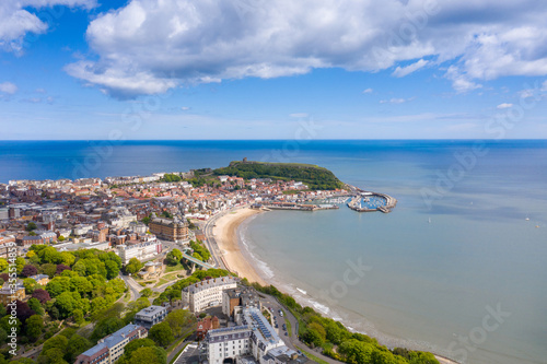Obraz na płótnie Aerial photo of the town centre of Scarborough in East Yorkshire in the UK showing the coastal beach and harbour with boats and the Scarborough Castle on a bright sunny summers day w salonie