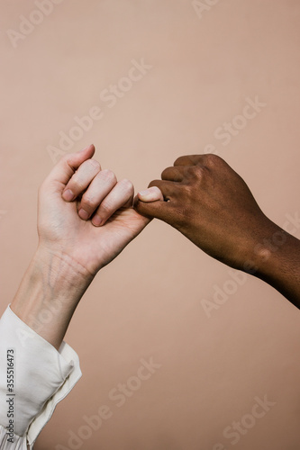 black and white hands making a pinky promise photo