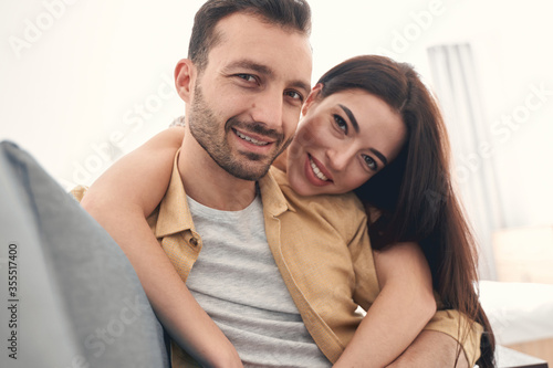 Smiling young man and woman embracing happily with love
