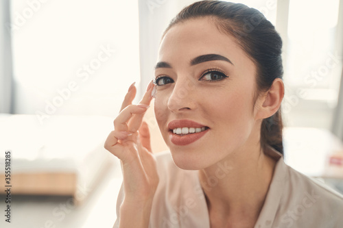 Beautiful smiling young lady making home spa procedures for skin