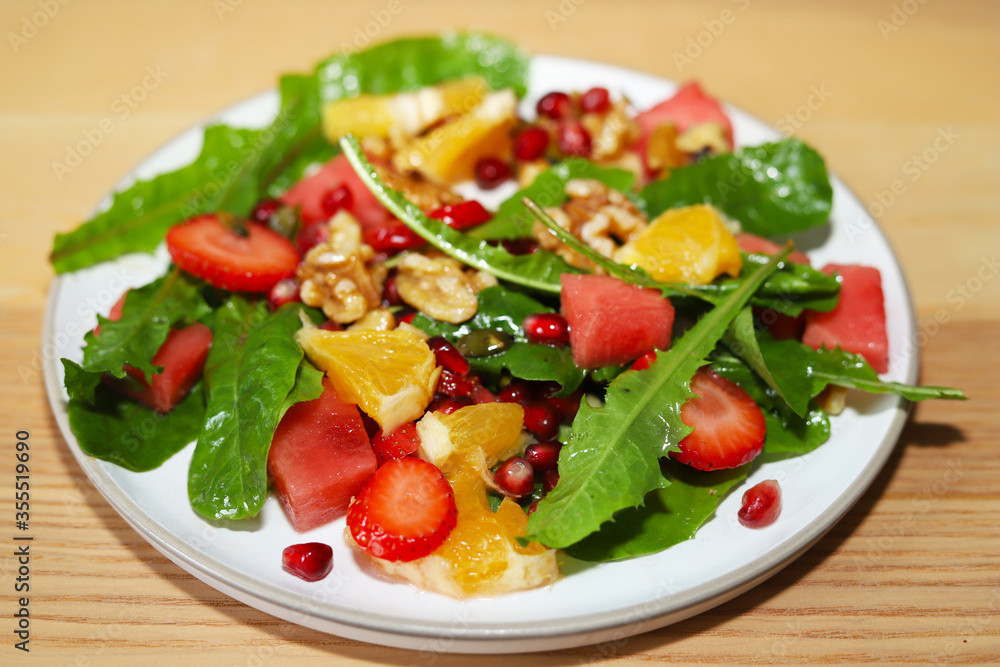 Colourful dandelion salad with fresh fruit.