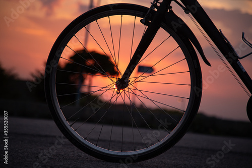 Closeup of bike front wheel with sunset in the background