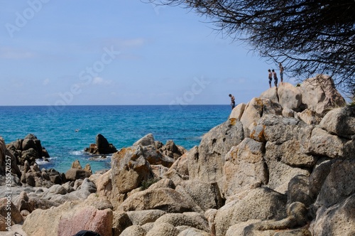 jeunes garçons plongeant depuis des rochers dans une mer turquoise sur fond de ciel bleu au sud de la corse