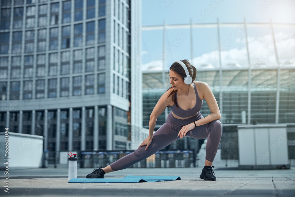 Obraz premium Fit dark-haired female performing a warm-up exercise