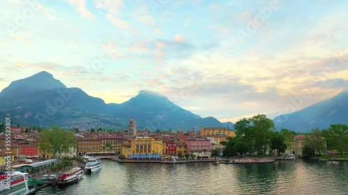 Aerial video with drone, view of the beautiful Riva del Garda town and Lake Garda lake surrounded by mountains in the autumn time , Trentino Alto Adige region, Lago di garda, italy