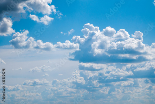 Several amorphous clouds against a large clear blue sky. Ideal for illustrating paradise © ILLIA ZOTOV
