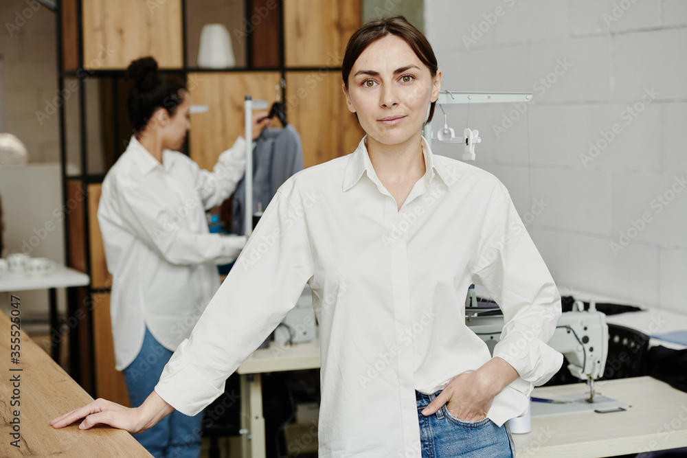 Fototapeta premium Pretty young fashion designer in white shirt standing in front of camera