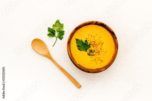 Pumpkin soup - with parsley and seeds - on white background top view