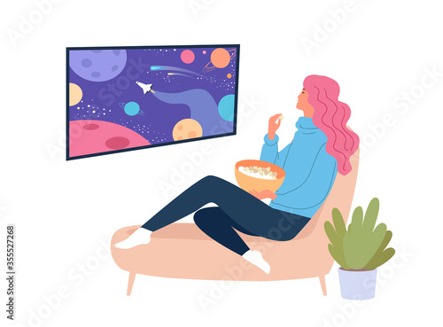 Young woman watching tv show about space and eating popcorn