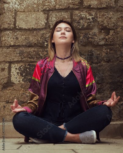 a young woman doing a yoga asana backside on the city street photo