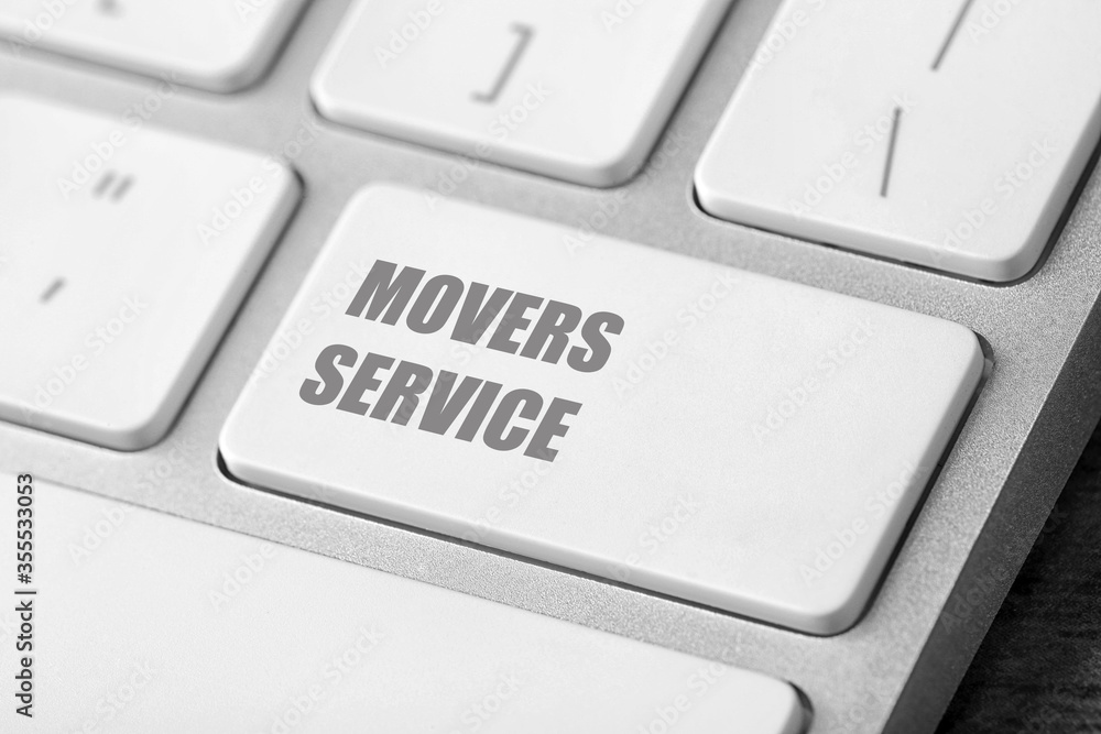 Modern computer keyboard with phrase MOVERS SERVICE on table, closeup Modern computer keyboard with phrase MOVERS SERVICE on table, closeup