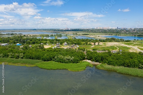 Aerial photo of Don river and beautiful green nature around. Summer city in the background.