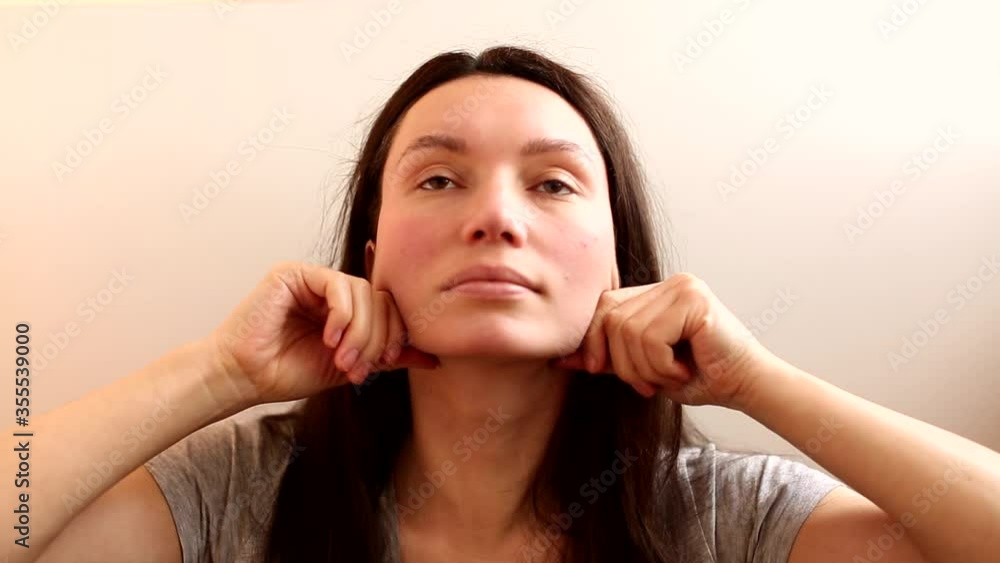 brunette girl does face massage, facebuilding, facelift, home care on the face, headshot brunette girl does face massage, facebuilding, facelift, home care on the face, headshot