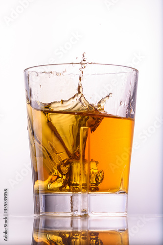  whiskey splashes in a glass on a light background1