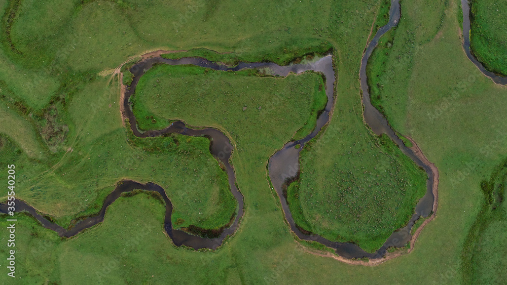 Meandering stream with mountains and clouds at The Persembe Plateau at Ordu, Turkey Drone and Aerial view Meandering stream with mountains and clouds at The Persembe Plateau at Ordu, Turkey Drone and Aerial view
