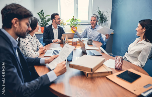Young managers discussing financial report with boss in office