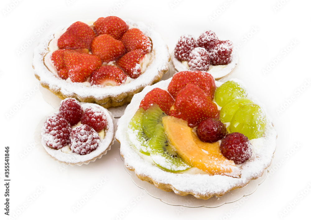 Small fruit cakes with various fruits and berries on white background Small fruit cakes with various fruits and berries on white background
