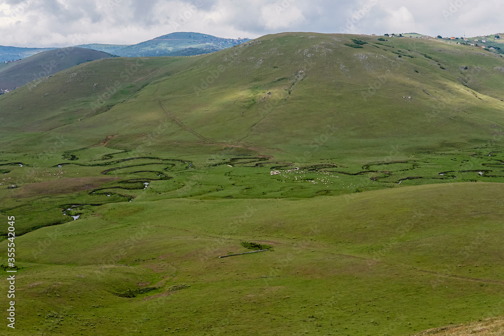 Meandering stream with mountains and clouds at The Persembe Plateau at Ordu, Turkey