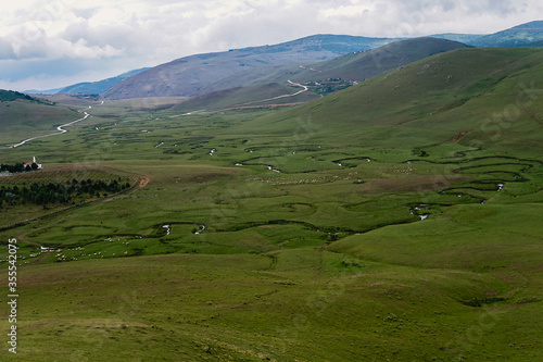 Meandering stream with mountains and clouds at The Persembe Plateau at Ordu  Turkey