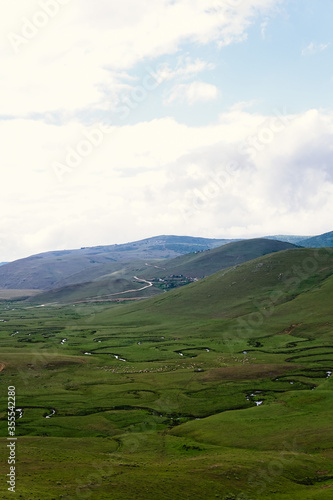 Meandering stream with mountains and clouds at The Persembe Plateau at Ordu, Turkey