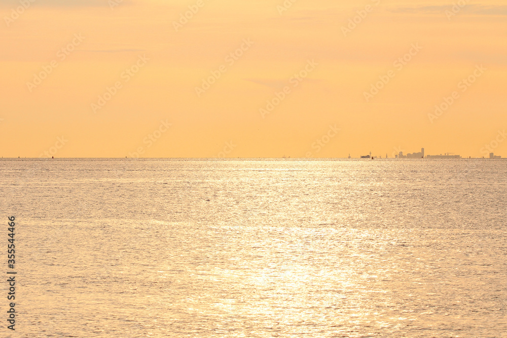 an endless sea and a beautiful orange sky above the horizon at a hot summer evening in zeeland, the netherlands over the westerschelde an endless sea and a beautiful orange sky above the horizon at a hot summer evening in zeeland, the netherlands over the westerschelde