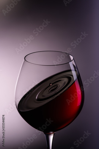 
a drop of wine flies into a wine glass1 photo