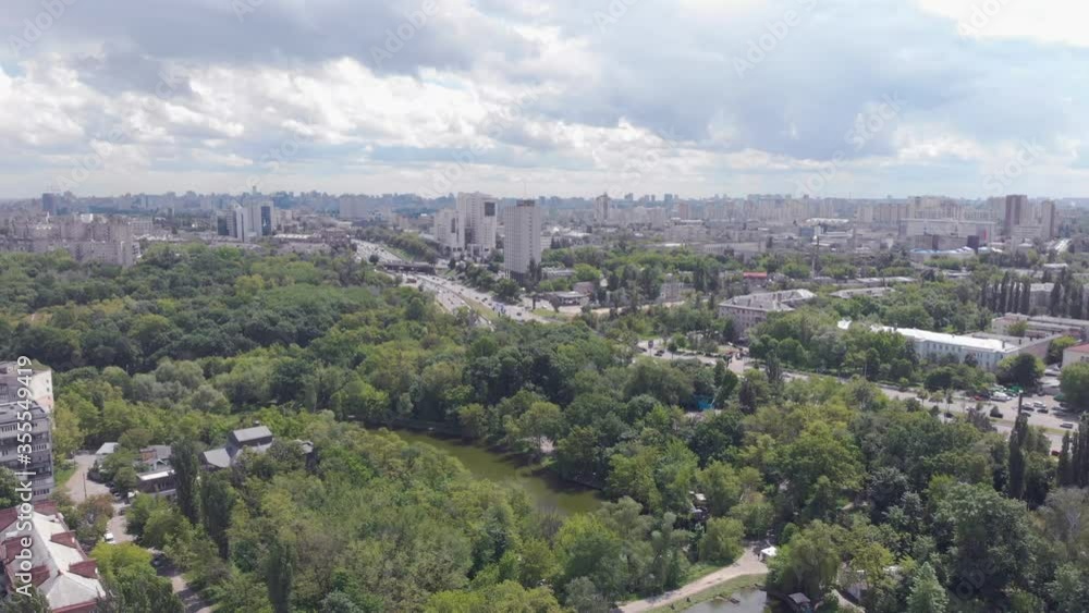 Park lake road and city aerial green trees clouds drone view camera movement Park lake road and city aerial green trees clouds drone view camera movement
