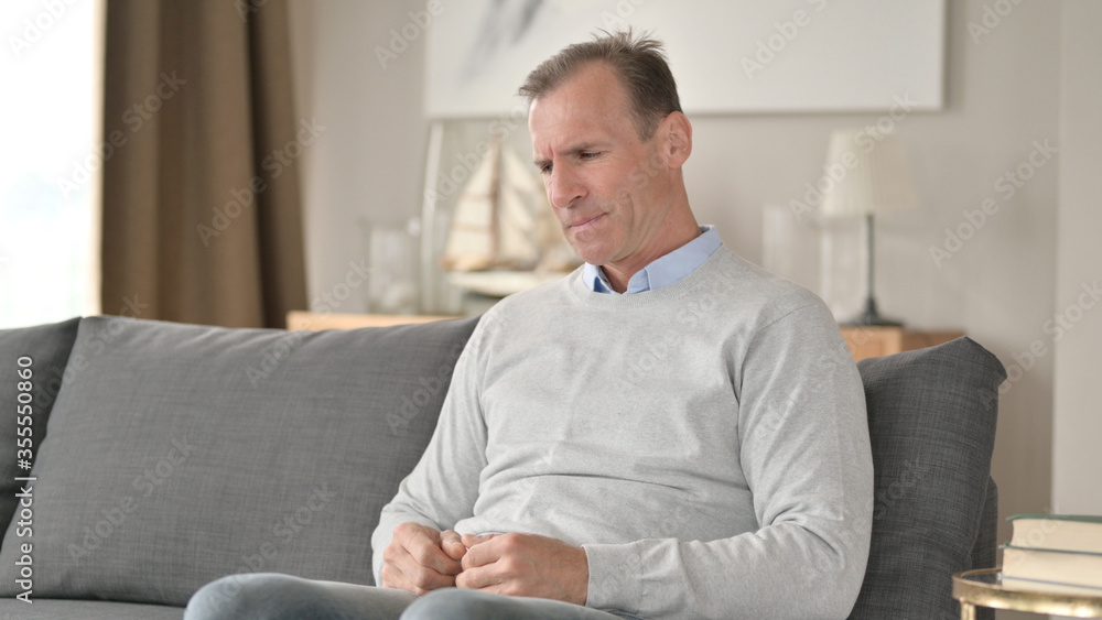 Worried Middle Aged Businessman Sitting on Sofa