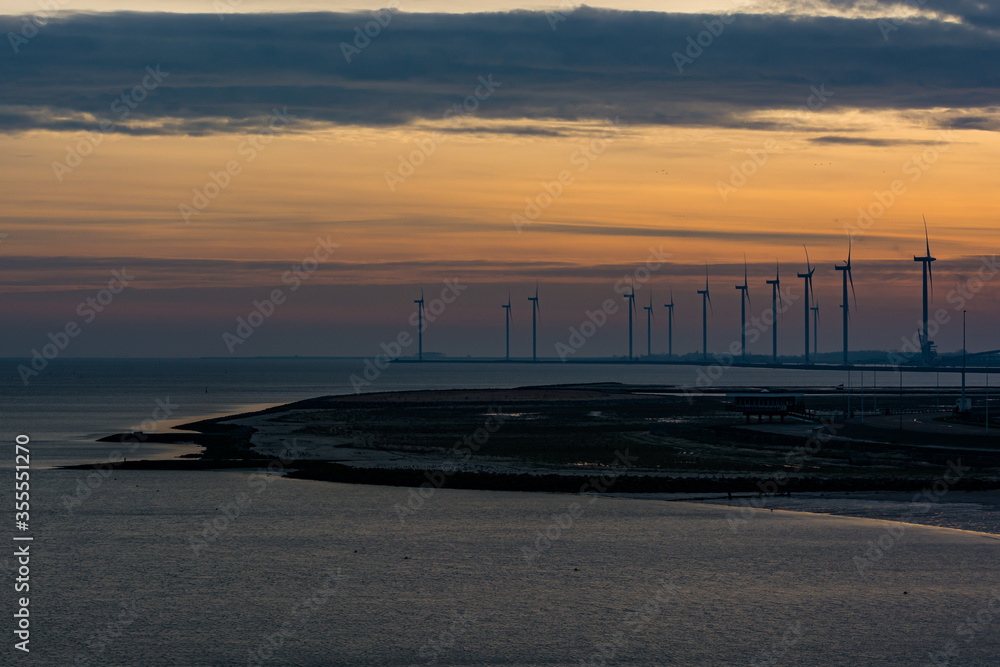 Wind electricity on the coast at night in Delfzijl, Netherlands
