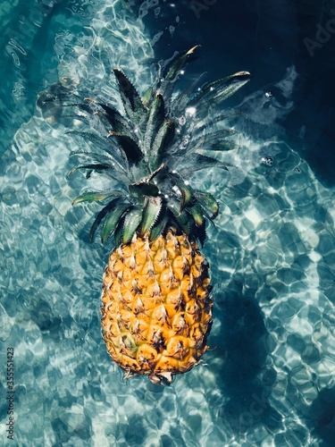 Pineapple floating in a water 