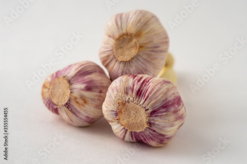 3 fresh garlic cloves on white background. Selective focus.