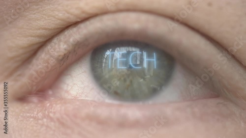 Glowing TECH word on human eye. Modern biotechnology related macro shot photo
