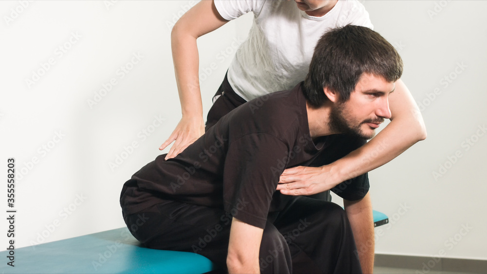 Physiotherapist exercising with disabled person on a therapy table. Physiotherapist exercising with disabled person on a therapy table.