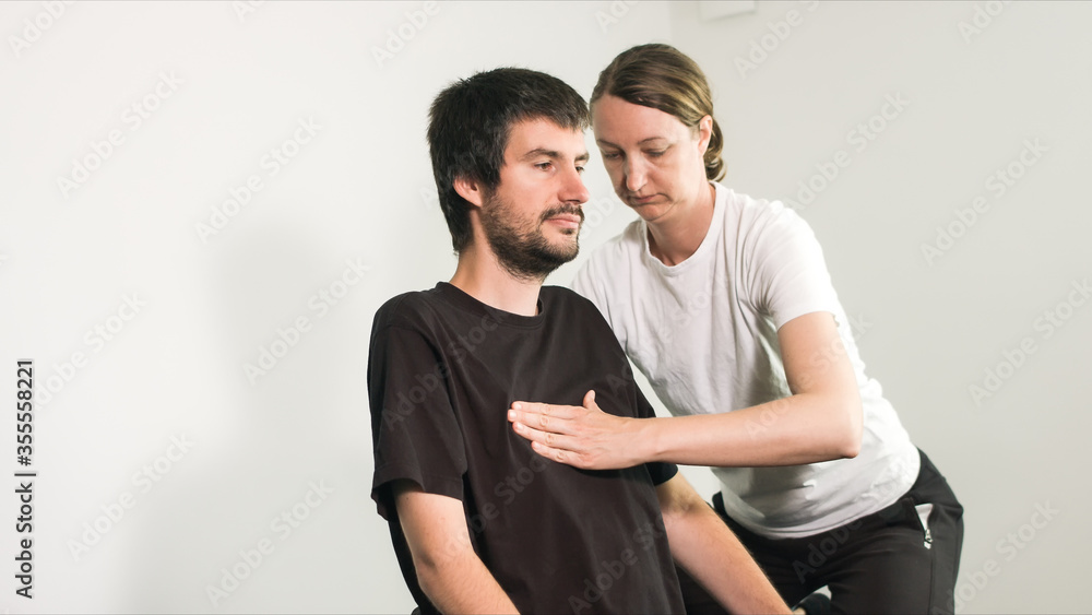 Physiotherapist exercising with disabled person on a therapy table. Physiotherapist exercising with disabled person on a therapy table.