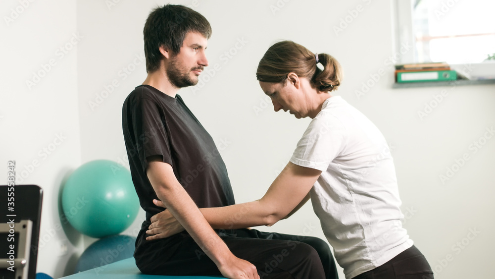 Physiotherapist exercising with disabled person on a therapy table. Physiotherapist exercising with disabled person on a therapy table.