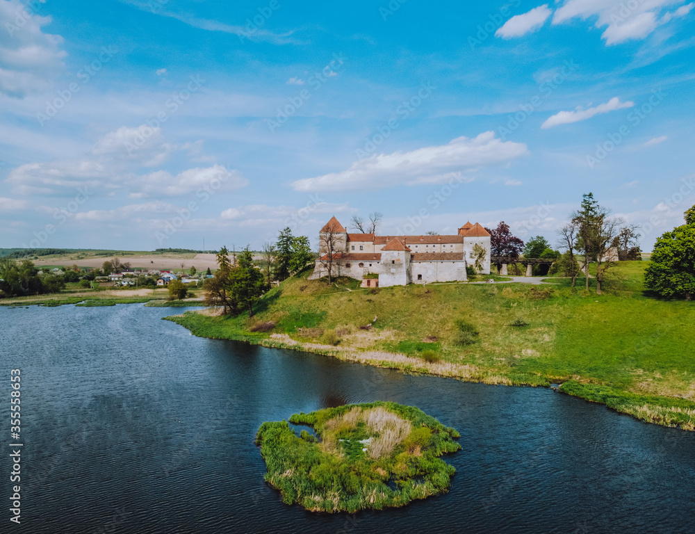 Aerial view to the old castle located at the shore of beautiful lake with small island in the middle. Aerial view to the old castle located at the shore of beautiful lake with small island in the middle.
