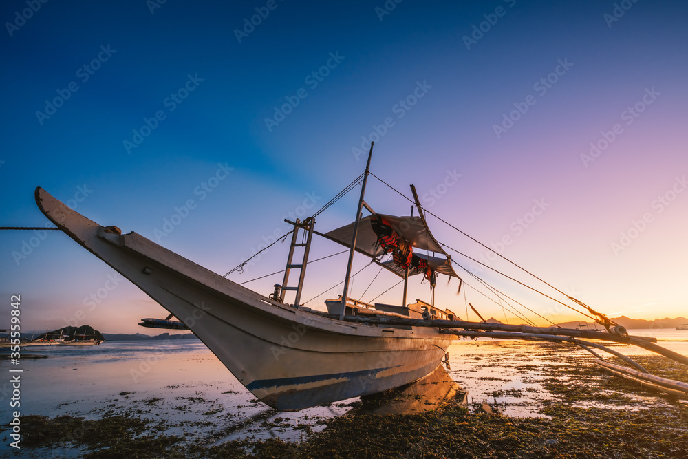 El Nido, Palawan island, Philippines. Boat in soft glow sunset light on tropical beach