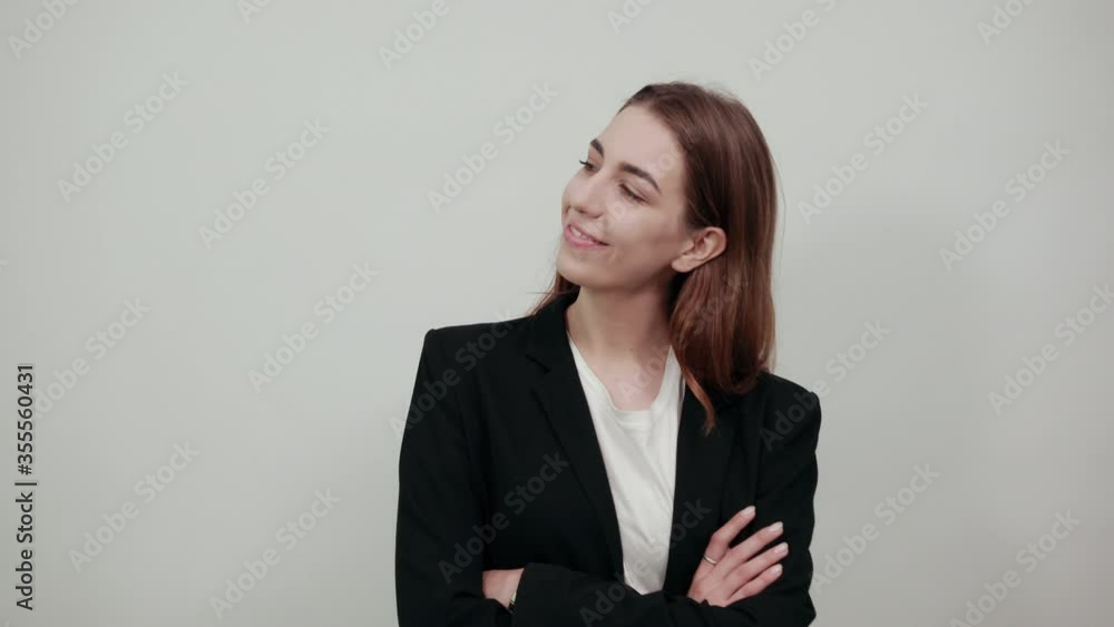 Standing and cross her arms on chest. Young attractive woman with brown hair in a light t-shirt, black jacket on white background. The look of concentrated women in side Standing and cross her arms on chest. Young attractive woman with brown hair in a light t-shirt, black jacket on white background. The look of concentrated women in side