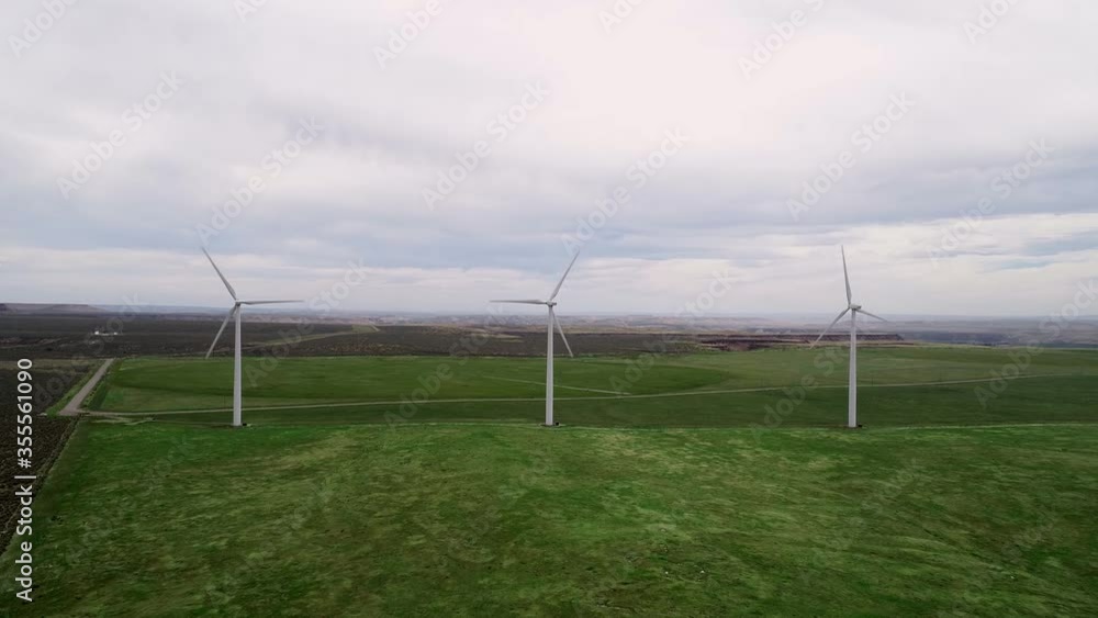 Several wind generators on a farm spinning in the wind Several wind generators on a farm spinning in the wind