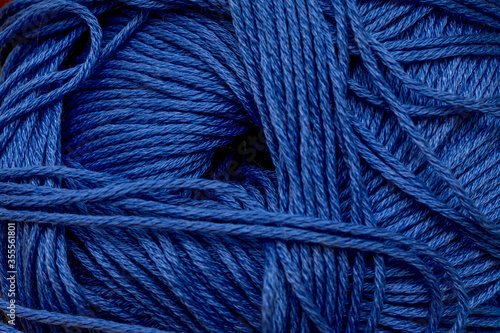 Yarn for knitting close-up blue background.